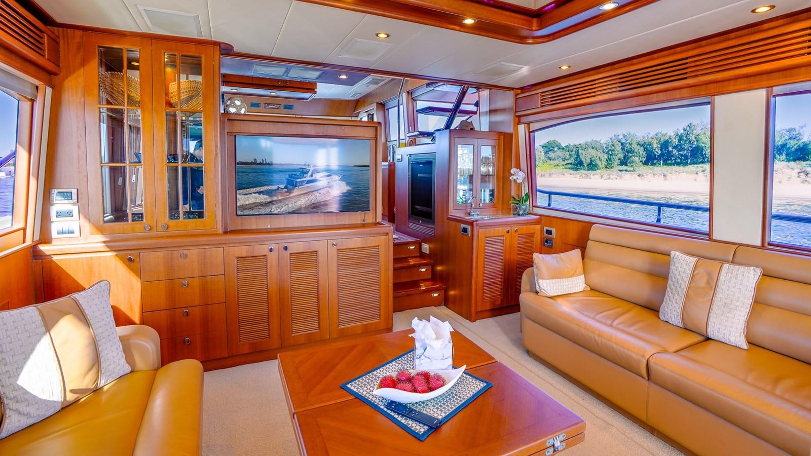 a living room with a table and couches aboard CAVALLINO III Yacht for Sale