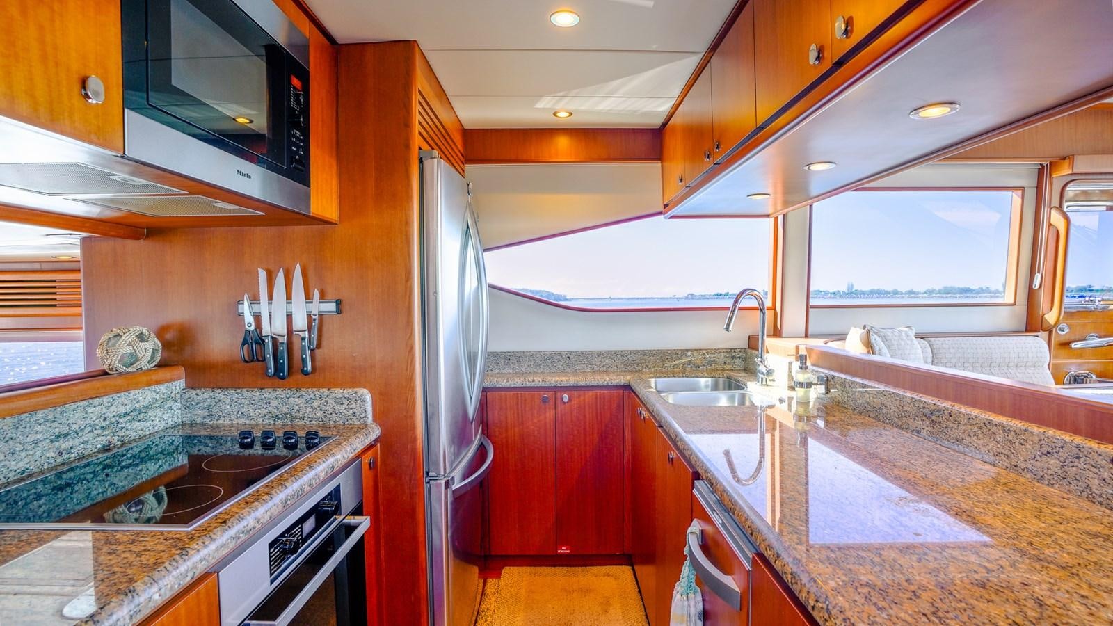 a kitchen with a stainless steel refrigerator aboard CAVALLINO III Yacht for Sale