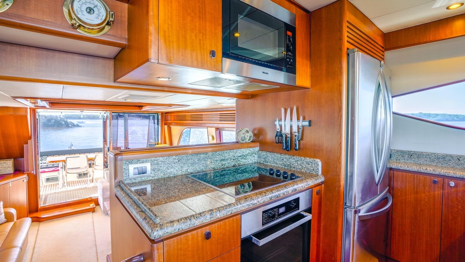 a kitchen with a stainless steel refrigerator aboard CAVALLINO III Yacht for Sale
