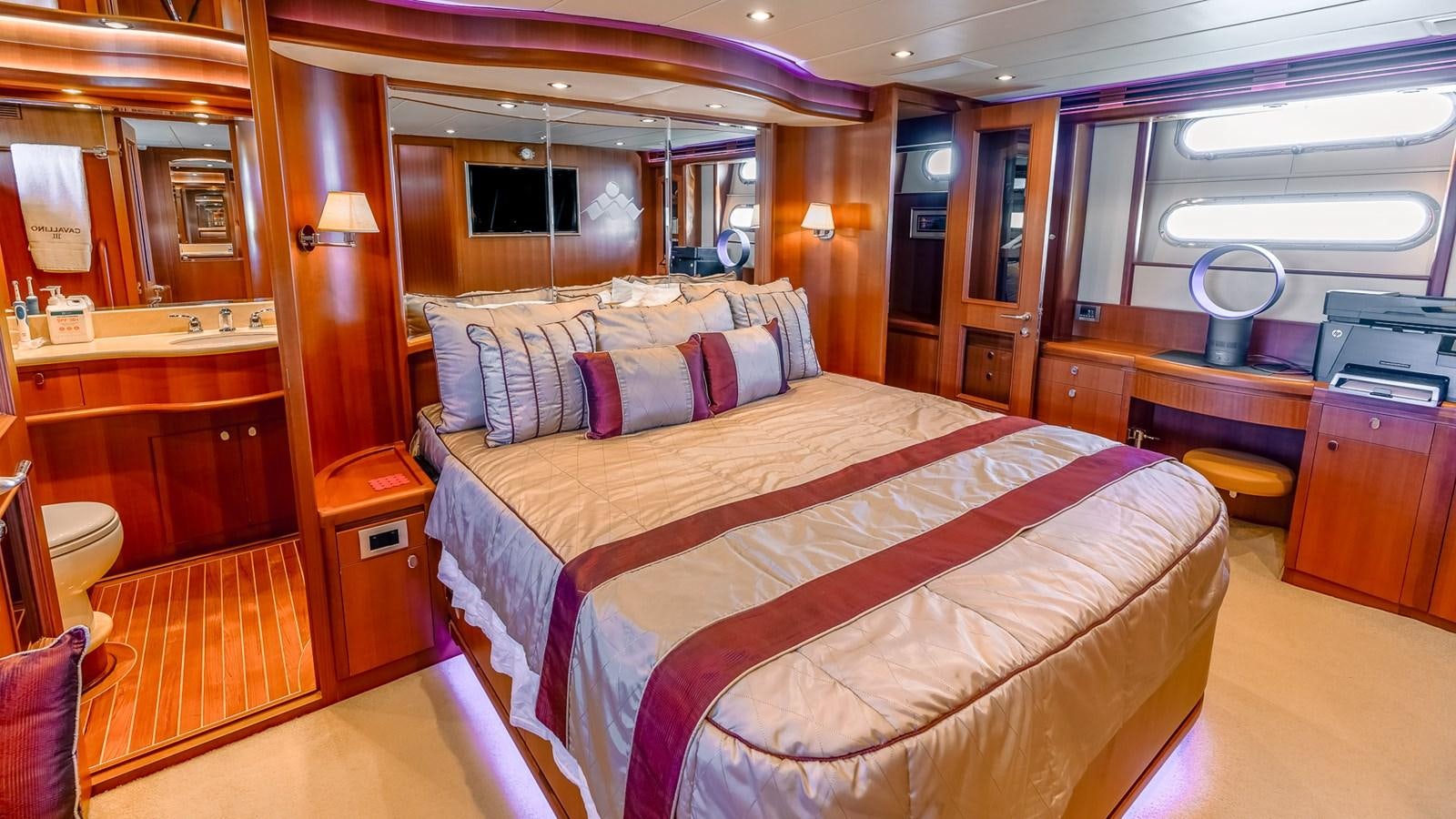 a bedroom with a bed and a desk aboard CAVALLINO III Yacht for Sale