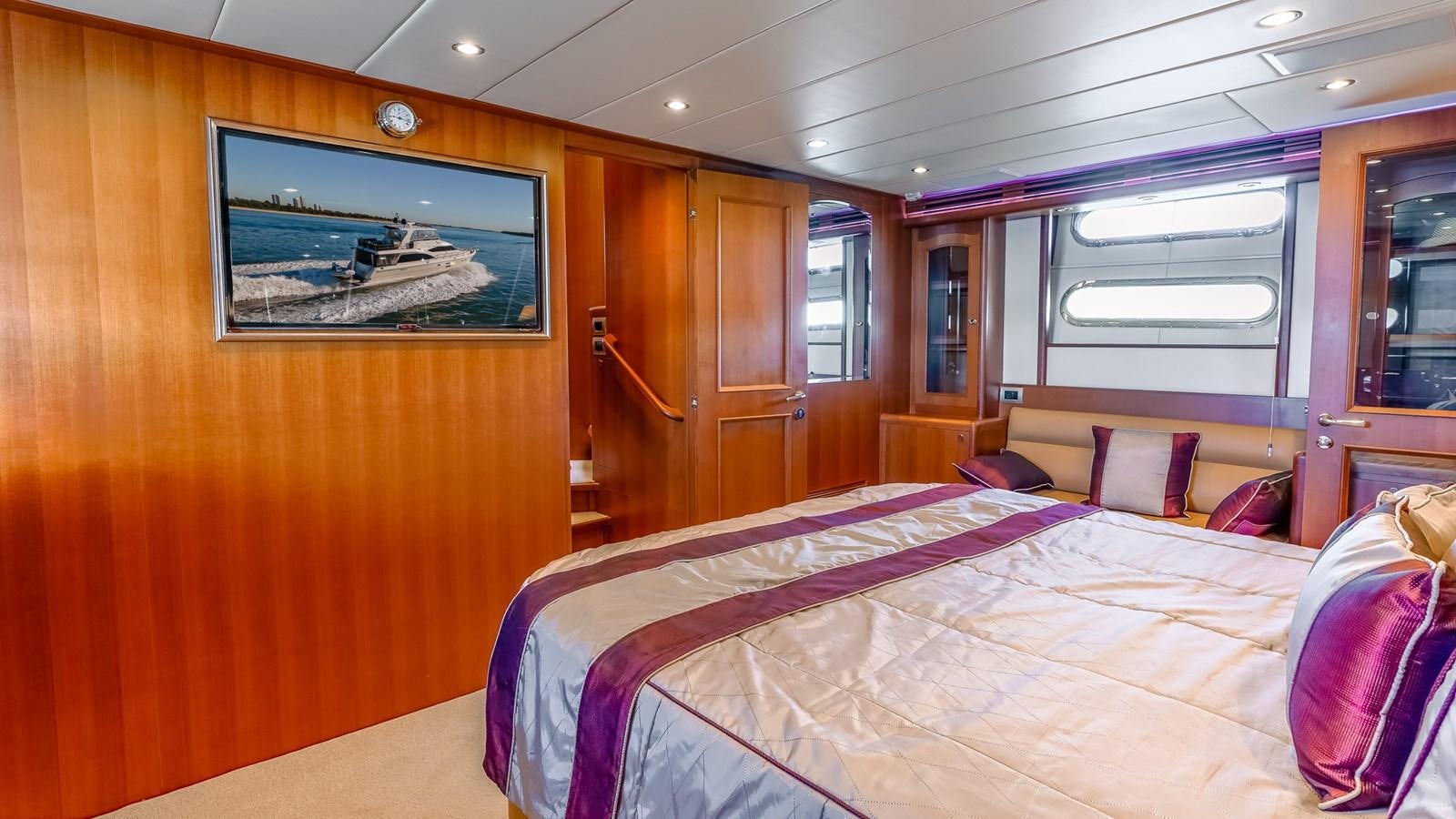 a bedroom with a bed and a television aboard CAVALLINO III Yacht for Sale