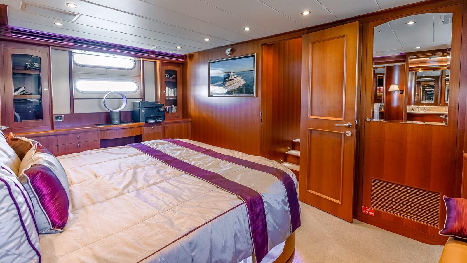 a bedroom with a bed and a mirror aboard CAVALLINO III Yacht for Sale