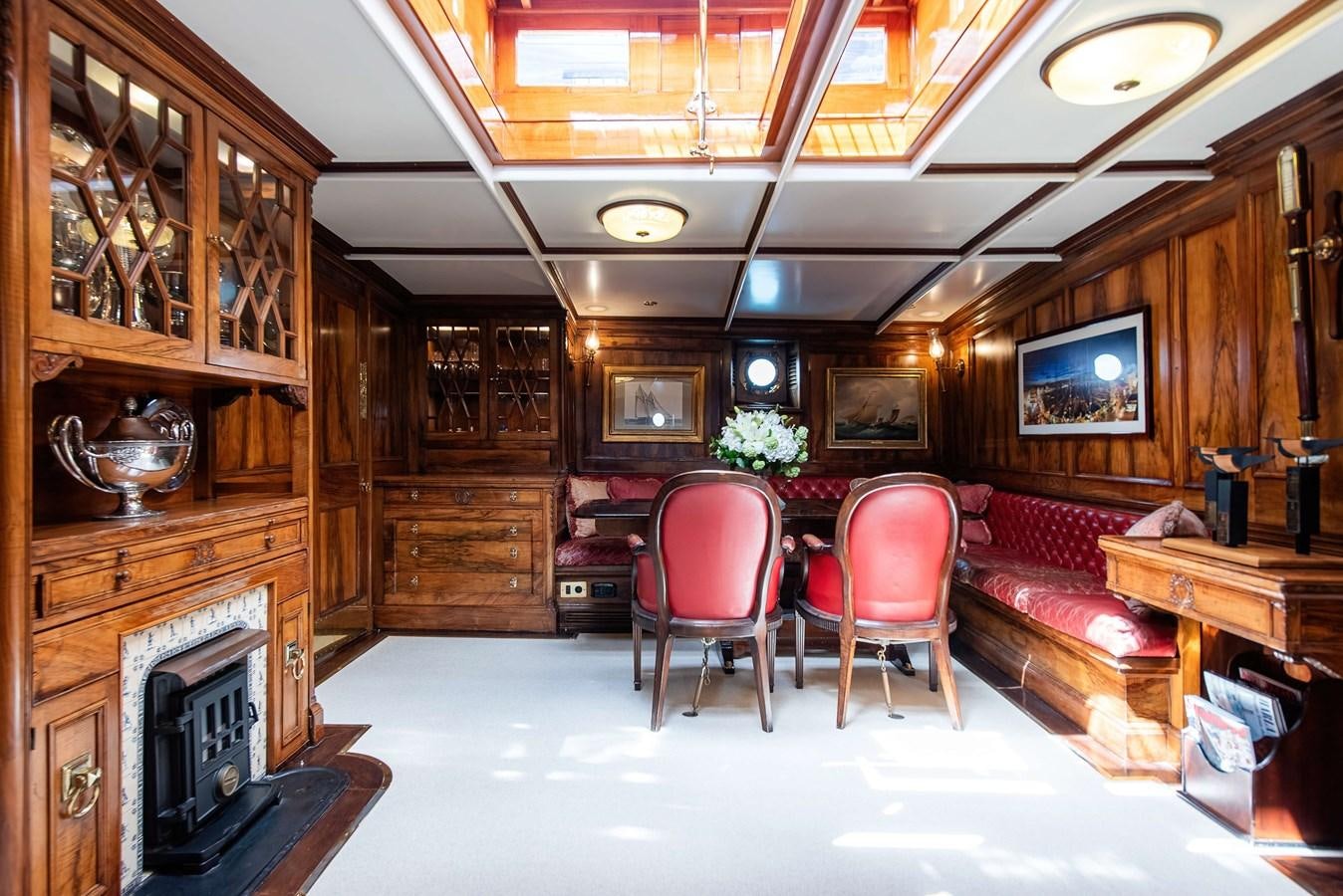 a room with a fireplace and chairs aboard MARIETTE OF 1915 Yacht for Sale