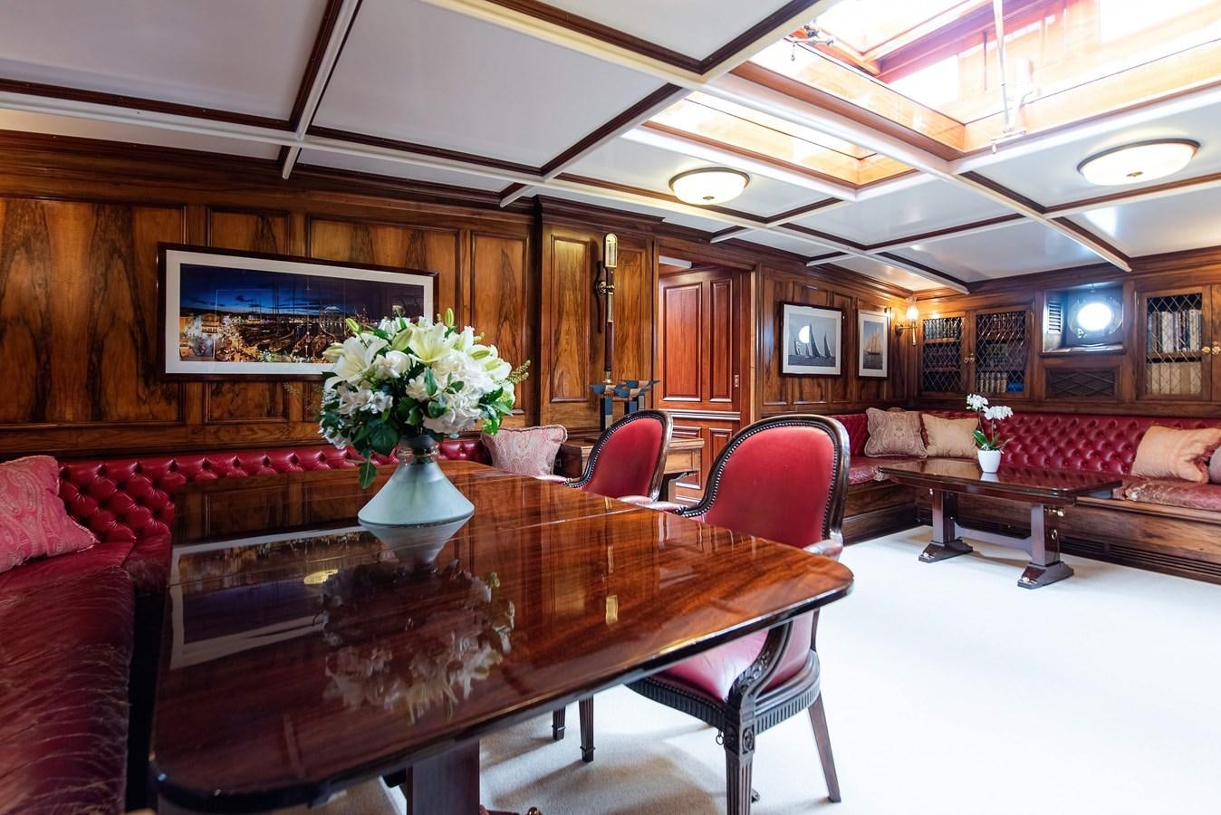 a large room with a table and chairs aboard MARIETTE OF 1915 Yacht for Sale