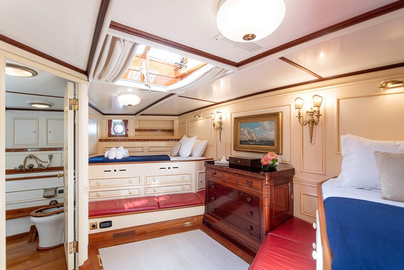 a bedroom with a bed and a dresser aboard MARIETTE OF 1915 Yacht for Sale