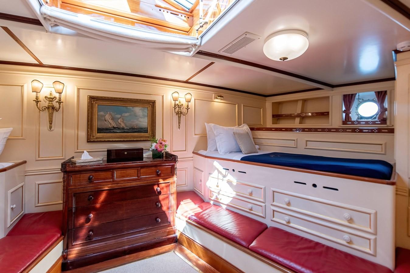 a bedroom with a bed and a dresser aboard MARIETTE OF 1915 Yacht for Sale