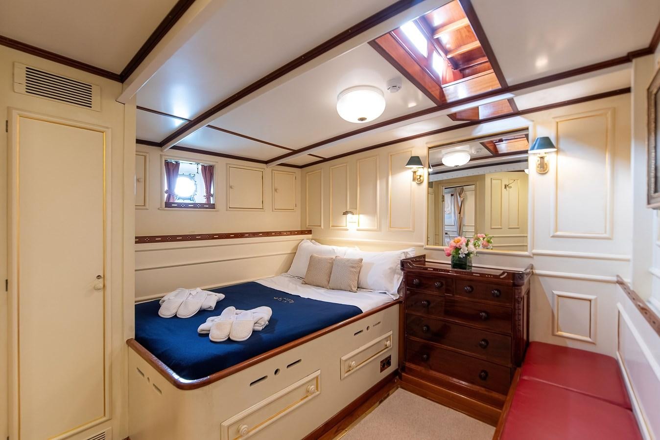 a bedroom with a bed and a dresser aboard MARIETTE OF 1915 Yacht for Sale
