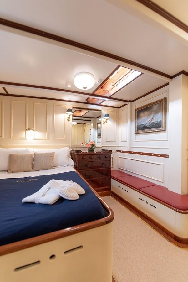 a bedroom with a bed and a dresser aboard MARIETTE OF 1915 Yacht for Sale