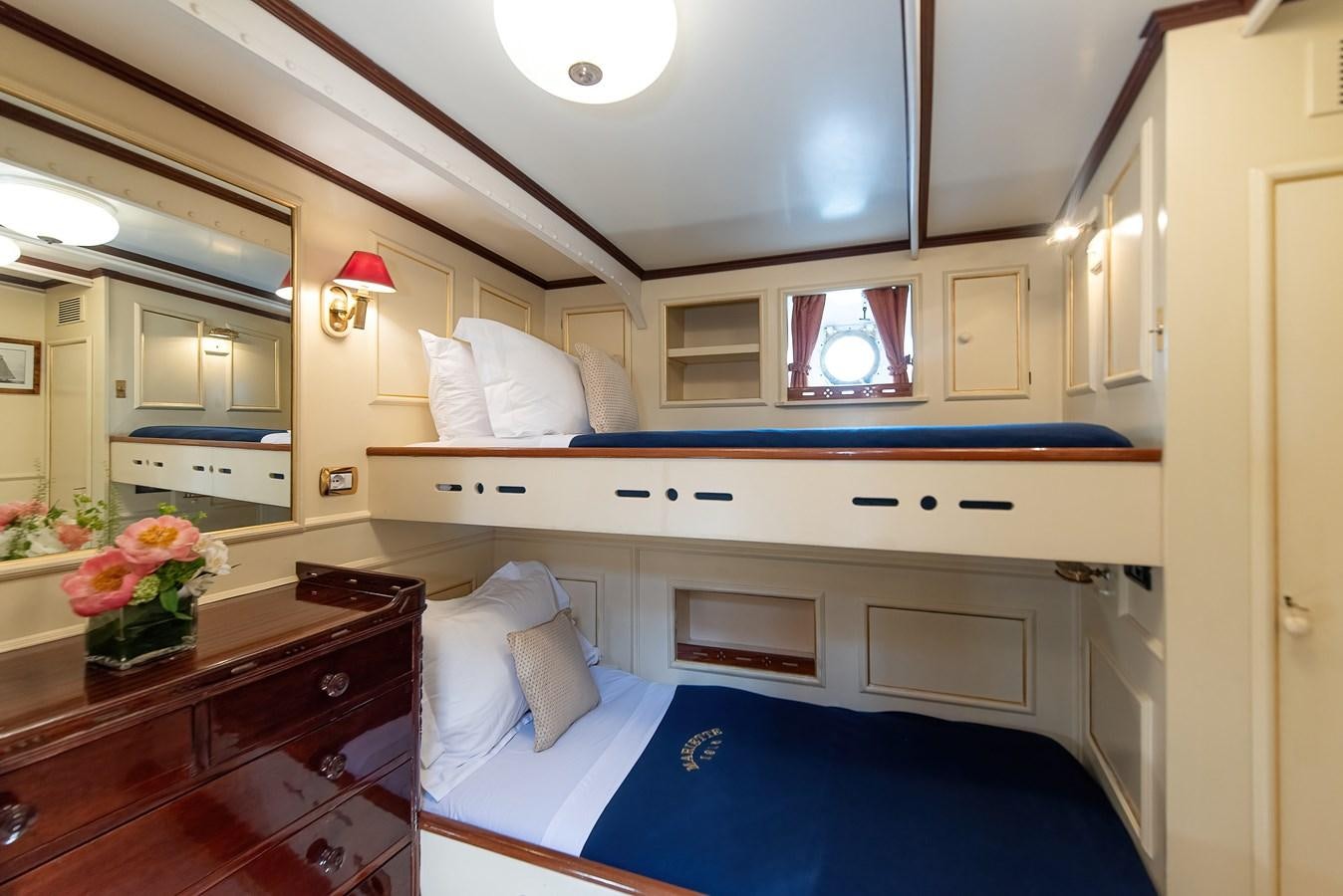 a bedroom with a bed and a desk aboard MARIETTE OF 1915 Yacht for Sale