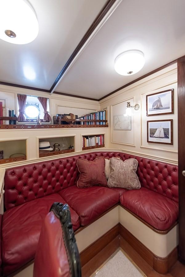 a red couch in a living room aboard MARIETTE OF 1915 Yacht for Sale