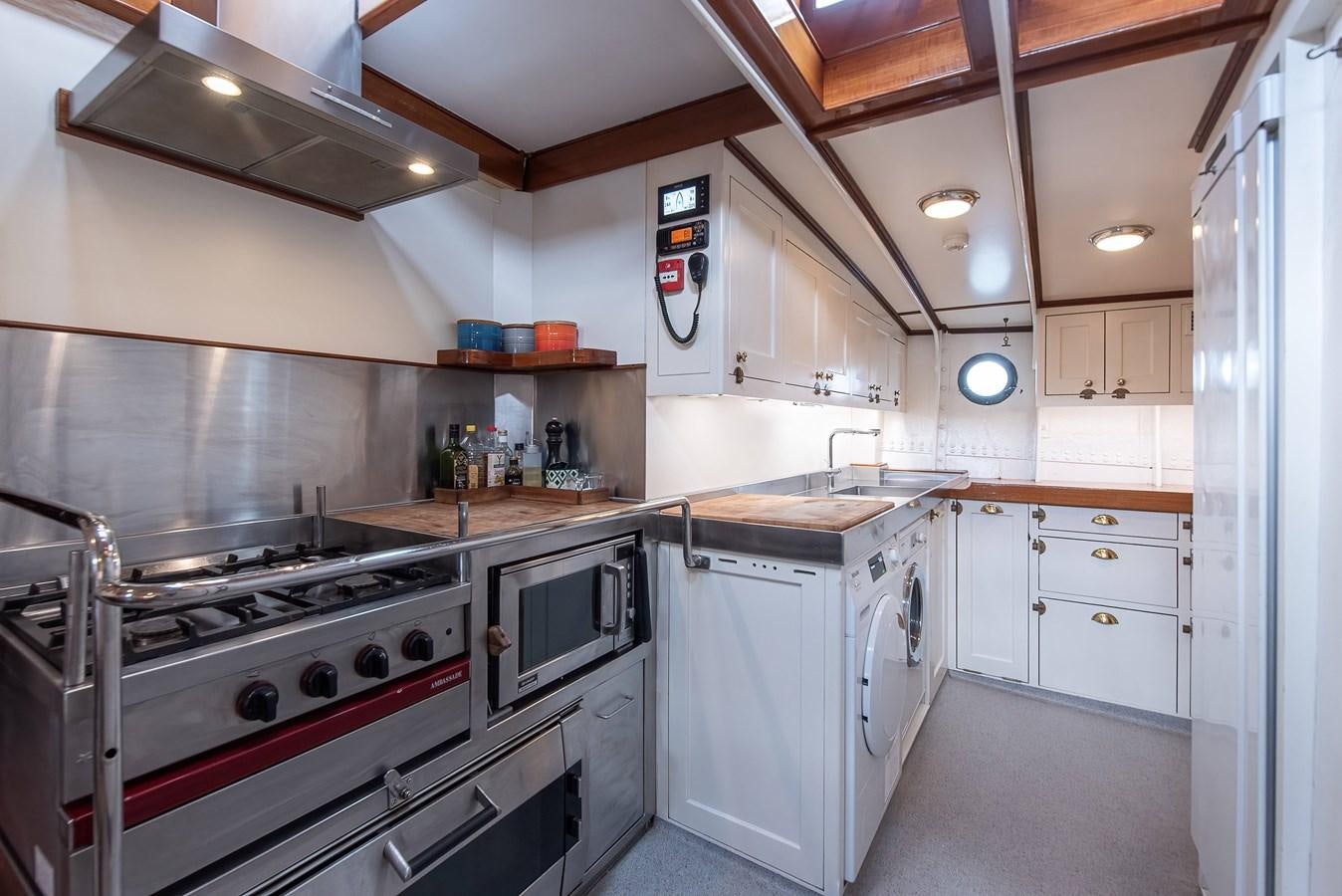 a kitchen with white cabinets aboard MARIETTE OF 1915 Yacht for Sale