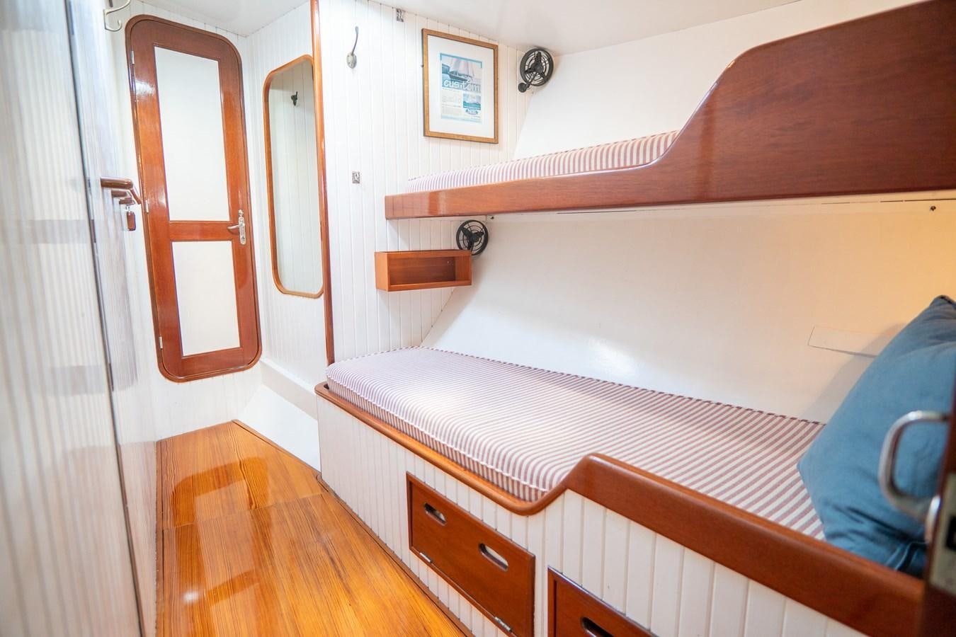 a bed with a wooden headboard aboard PIAFFE Yacht for Sale