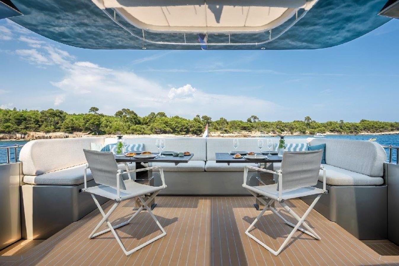 a deck with chairs and a table on it aboard ST. BARTH Yacht for Sale