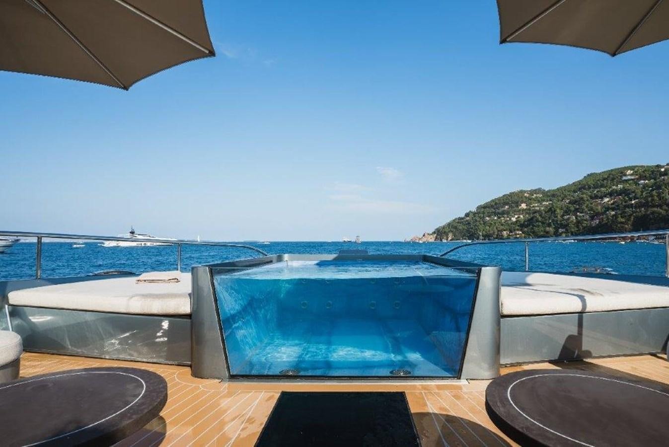 a pool with a view of the ocean and mountains in the background aboard ST. BARTH Yacht for Sale