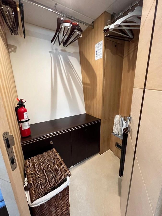 a room with a shelf and a red fire extinguisher aboard ESCAPE Yacht for Sale