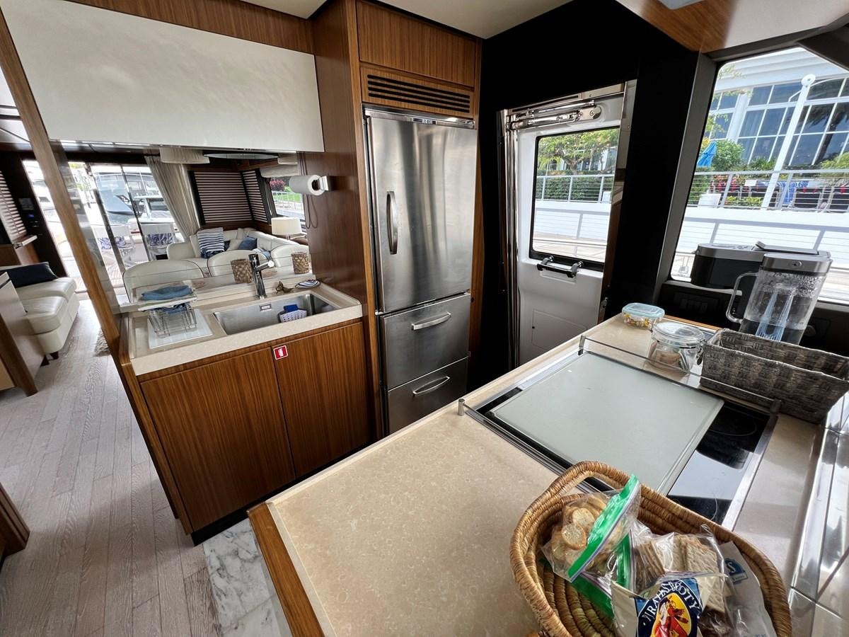 a kitchen with a stainless steel refrigerator aboard PURA VIDA Yacht for Sale
