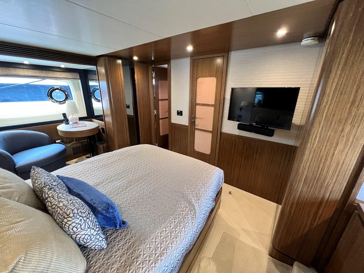 a room with a bed and a television aboard PURA VIDA Yacht for Sale