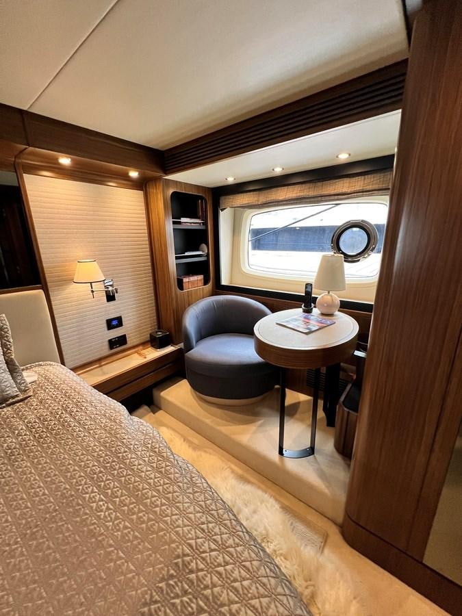 a bedroom with a bed and a table aboard PURA VIDA Yacht for Sale