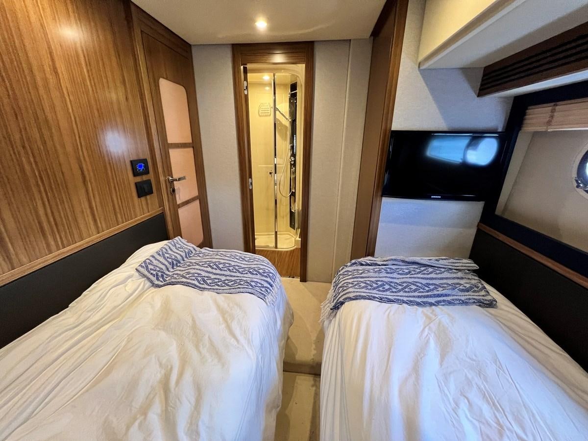 a room with a bed and a television aboard PURA VIDA Yacht for Sale