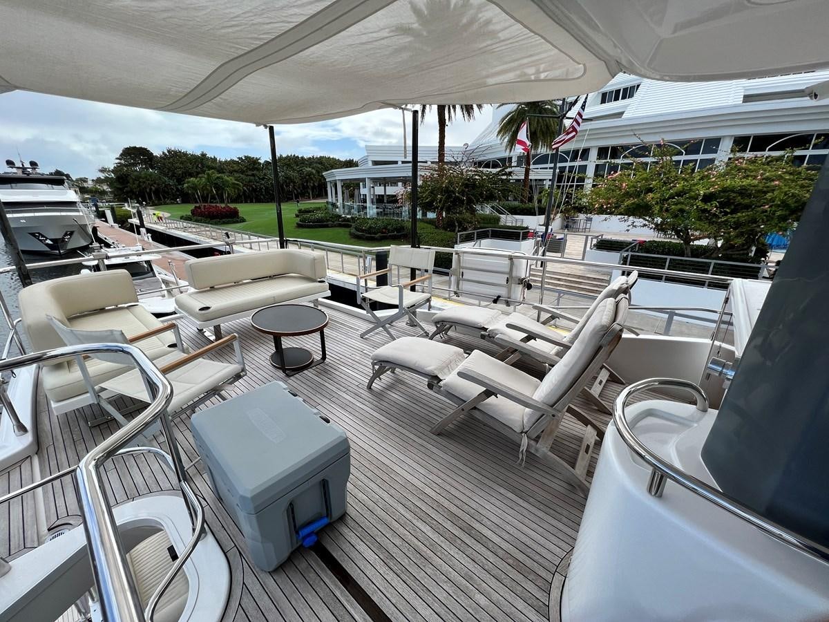 a deck with chairs and a table aboard PURA VIDA Yacht for Sale