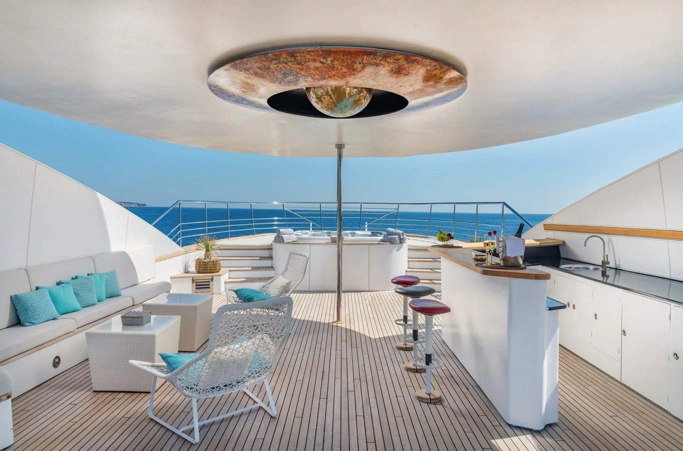 a room with a large white table and chairs and a large round white object on the ceiling with aboard JOY ME Yacht for Sale