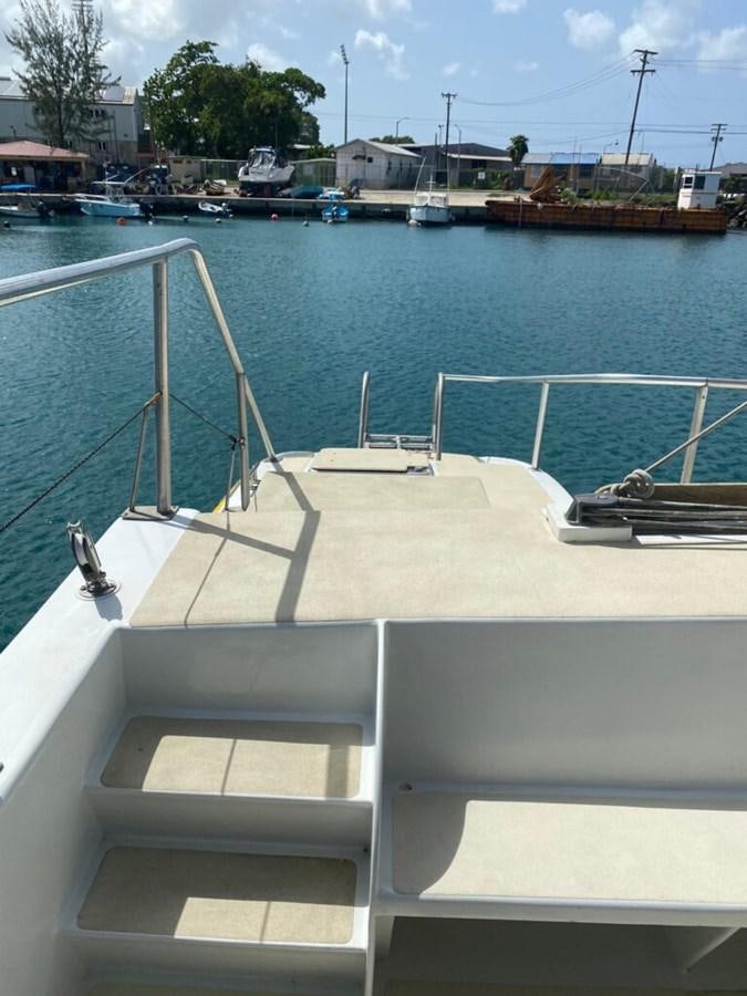 a white boat on a body of water aboard 1996 GOLD COAST GC 70 Yacht for Sale