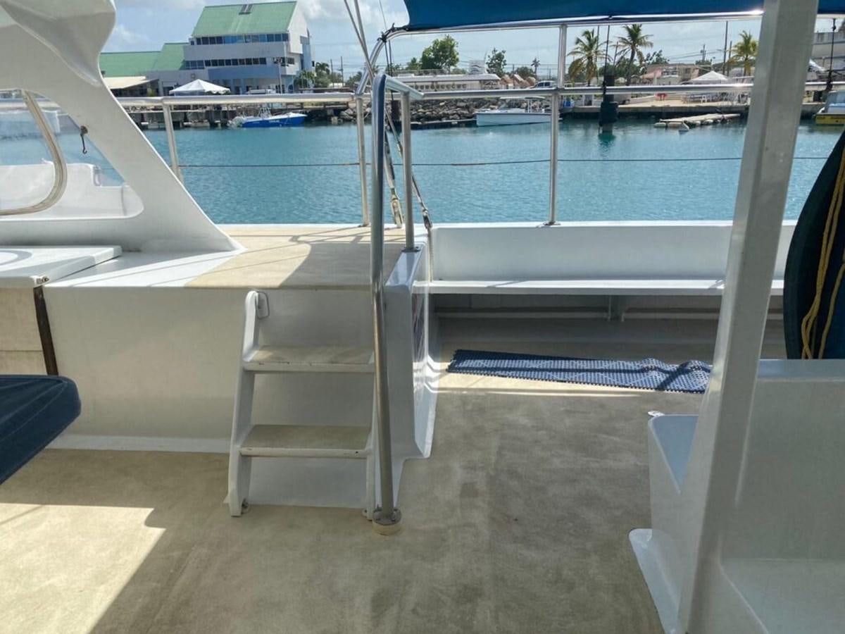 a white chair on a deck by a body of water aboard 1996 GOLD COAST GC 70 Yacht for Sale