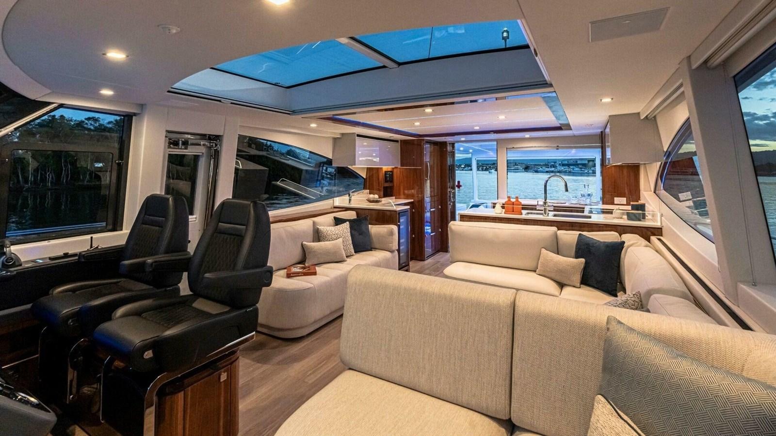 a living room with a couch and a large window aboard 6800 SPORT  PLATINUM Yacht for Sale