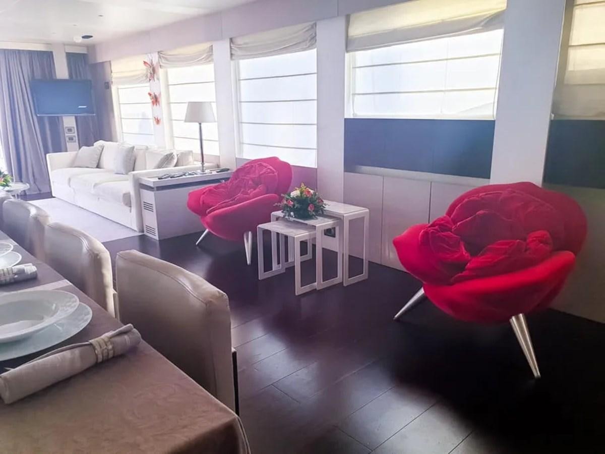 a living room with a red chair aboard AURORA Yacht for Sale