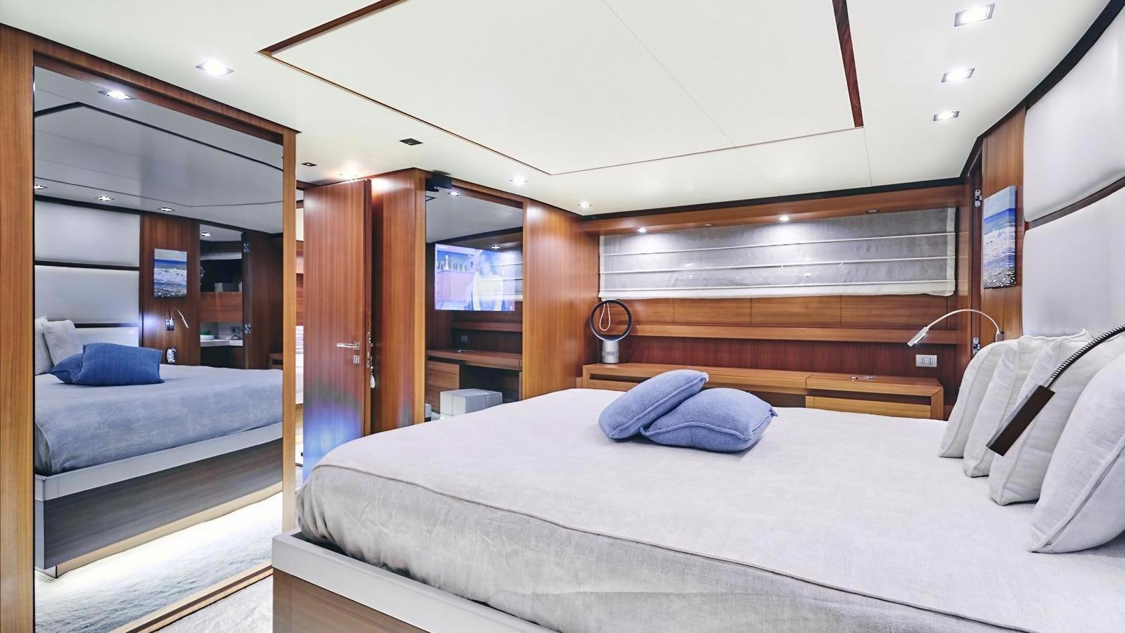 a room with a bed and a wood cabinet aboard SUNRAY II Yacht for Sale