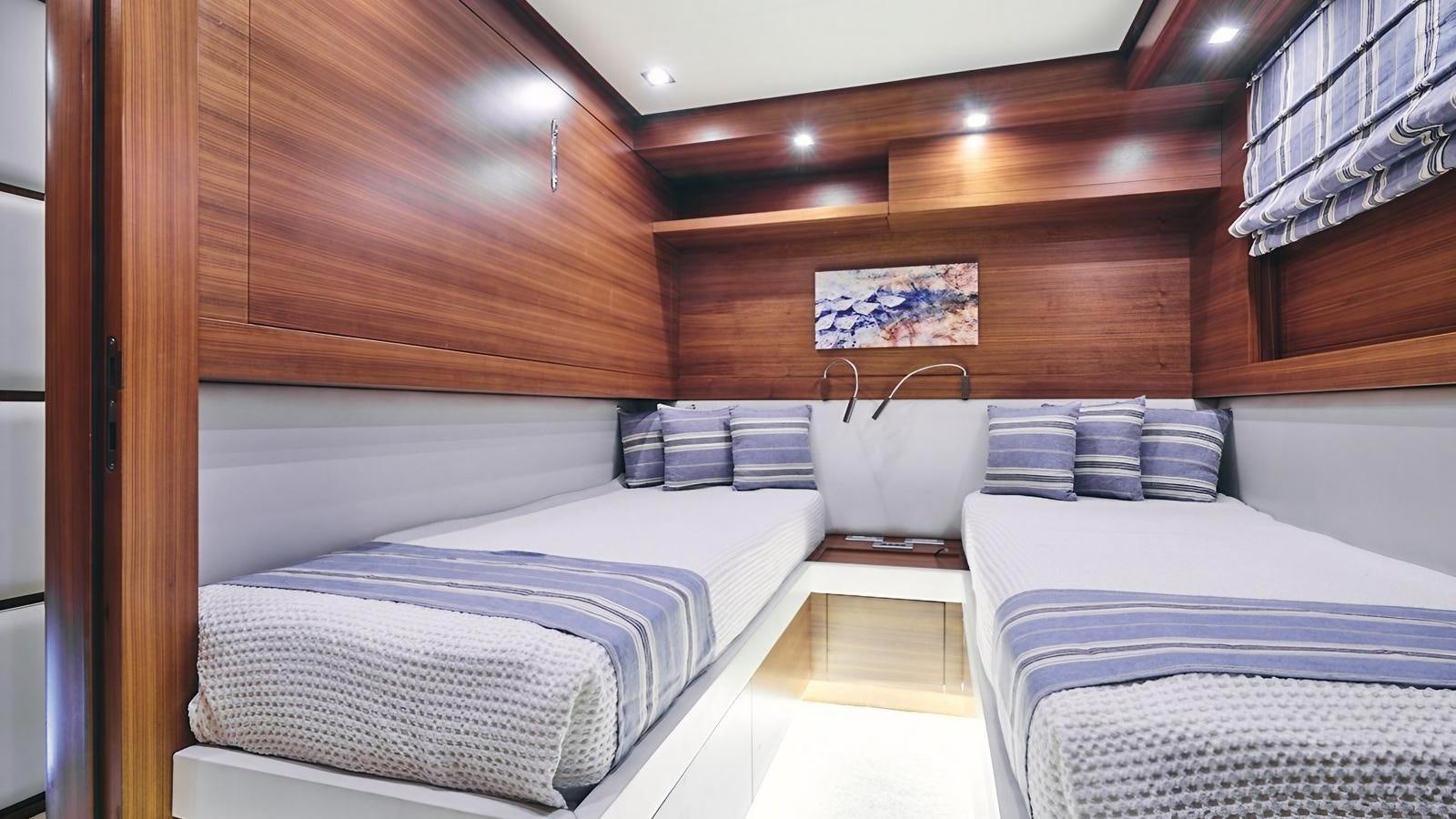 a room with beds and a wood wall aboard SUNRAY II Yacht for Sale