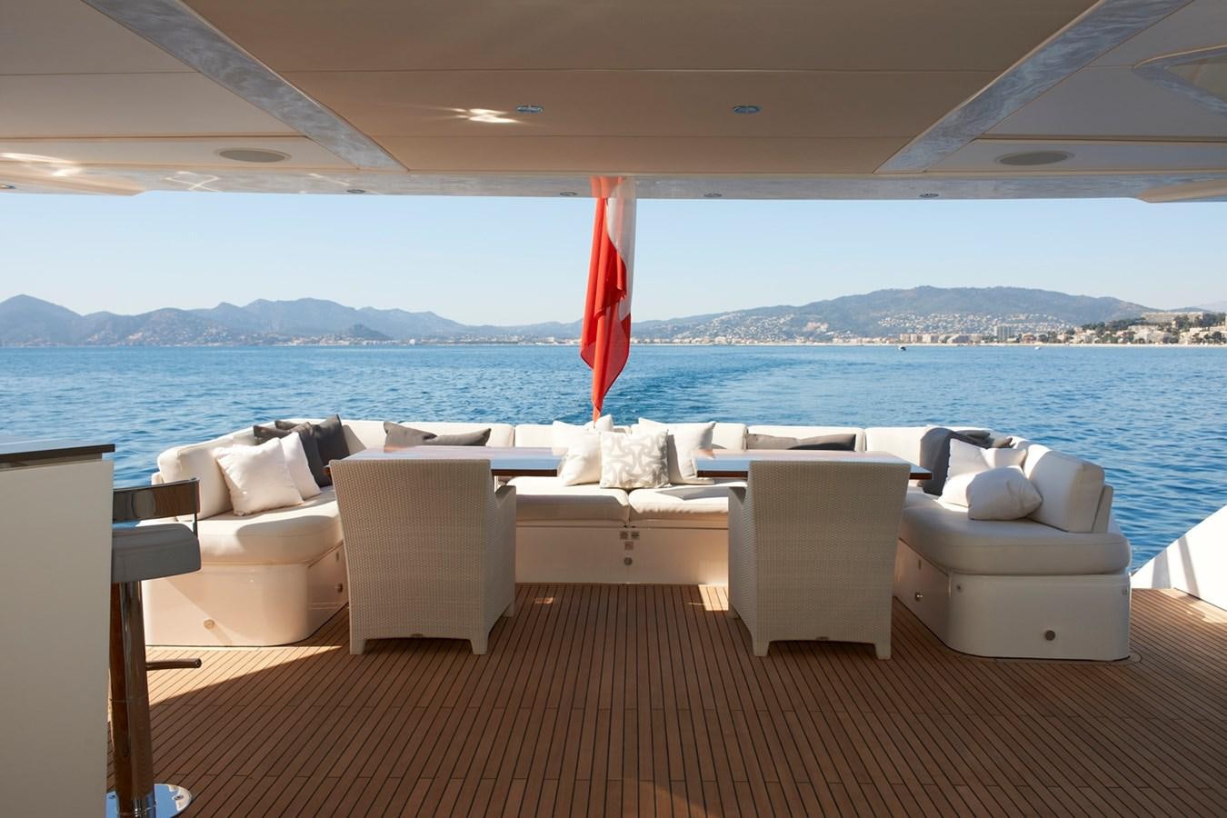 a boat with white chairs and a red flag on the deck aboard IMPERIAL PRINCESS BEATRICE Yacht for Sale