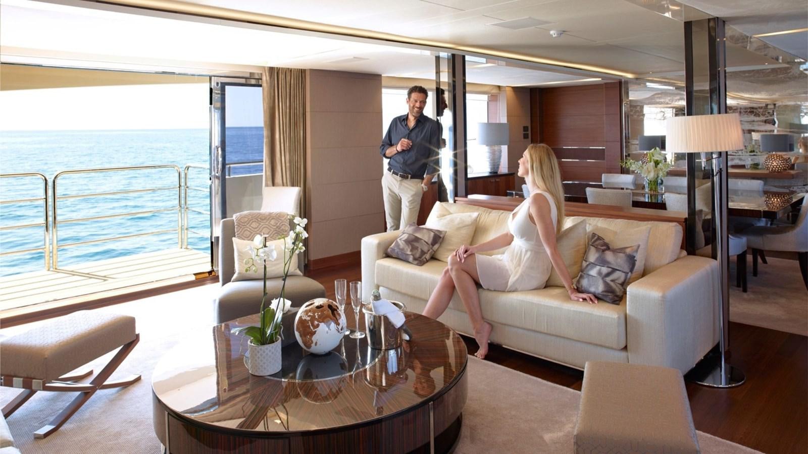 a man and woman standing in a living room aboard IMPERIAL PRINCESS BEATRICE Yacht for Sale