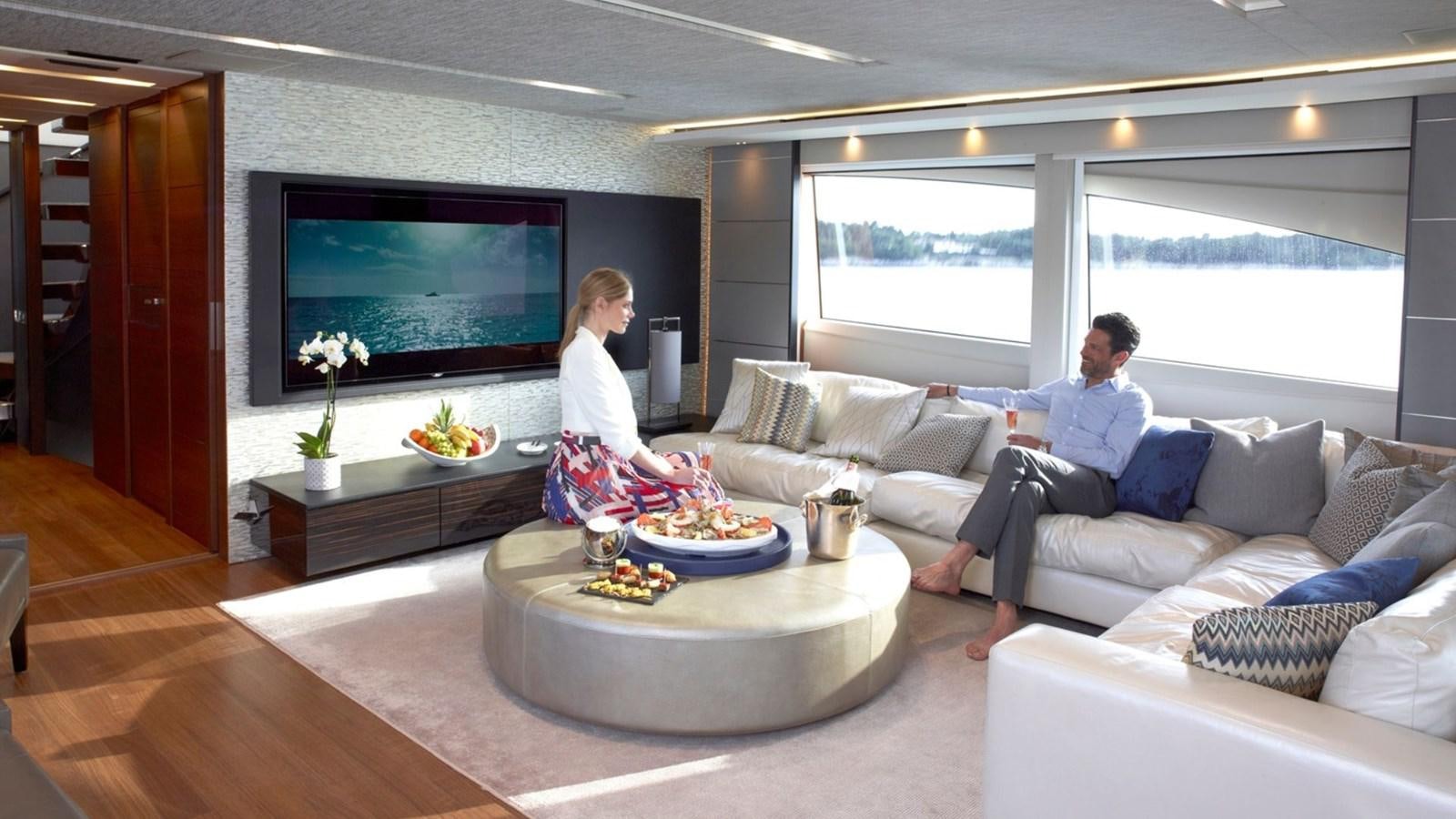 a man and woman sitting on a couch in a living room aboard IMPERIAL PRINCESS BEATRICE Yacht for Sale