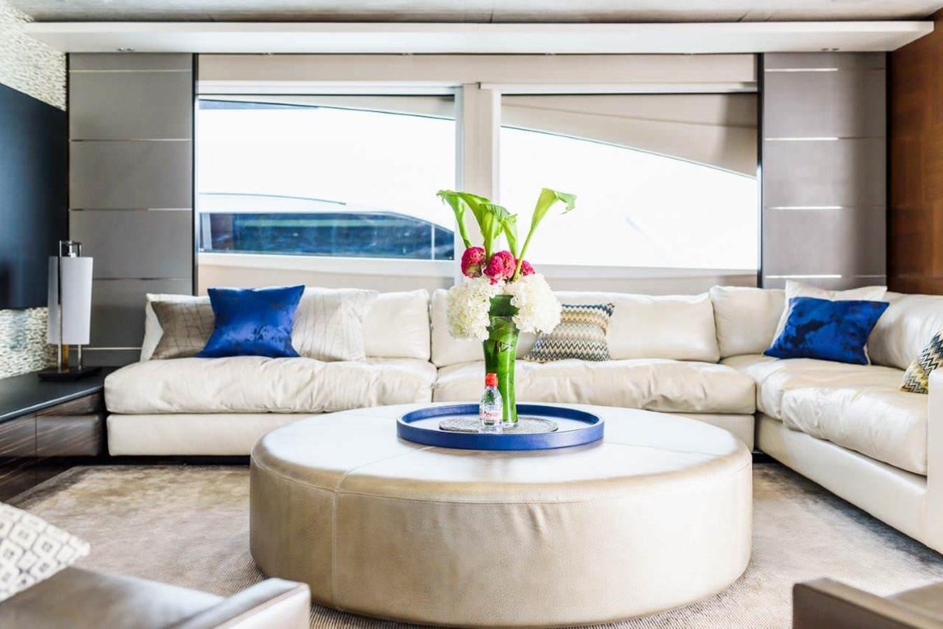a living room with a white couch and a vase of flowers on a table aboard IMPERIAL PRINCESS BEATRICE Yacht for Sale