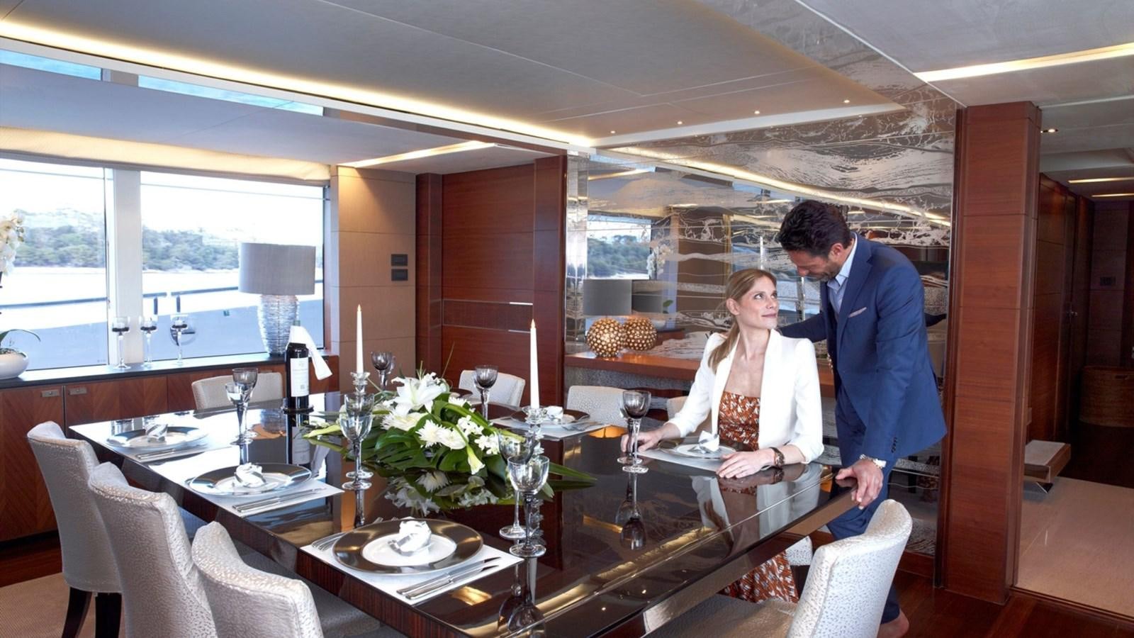 a man and a woman standing at a table with wine glasses aboard IMPERIAL PRINCESS BEATRICE Yacht for Sale