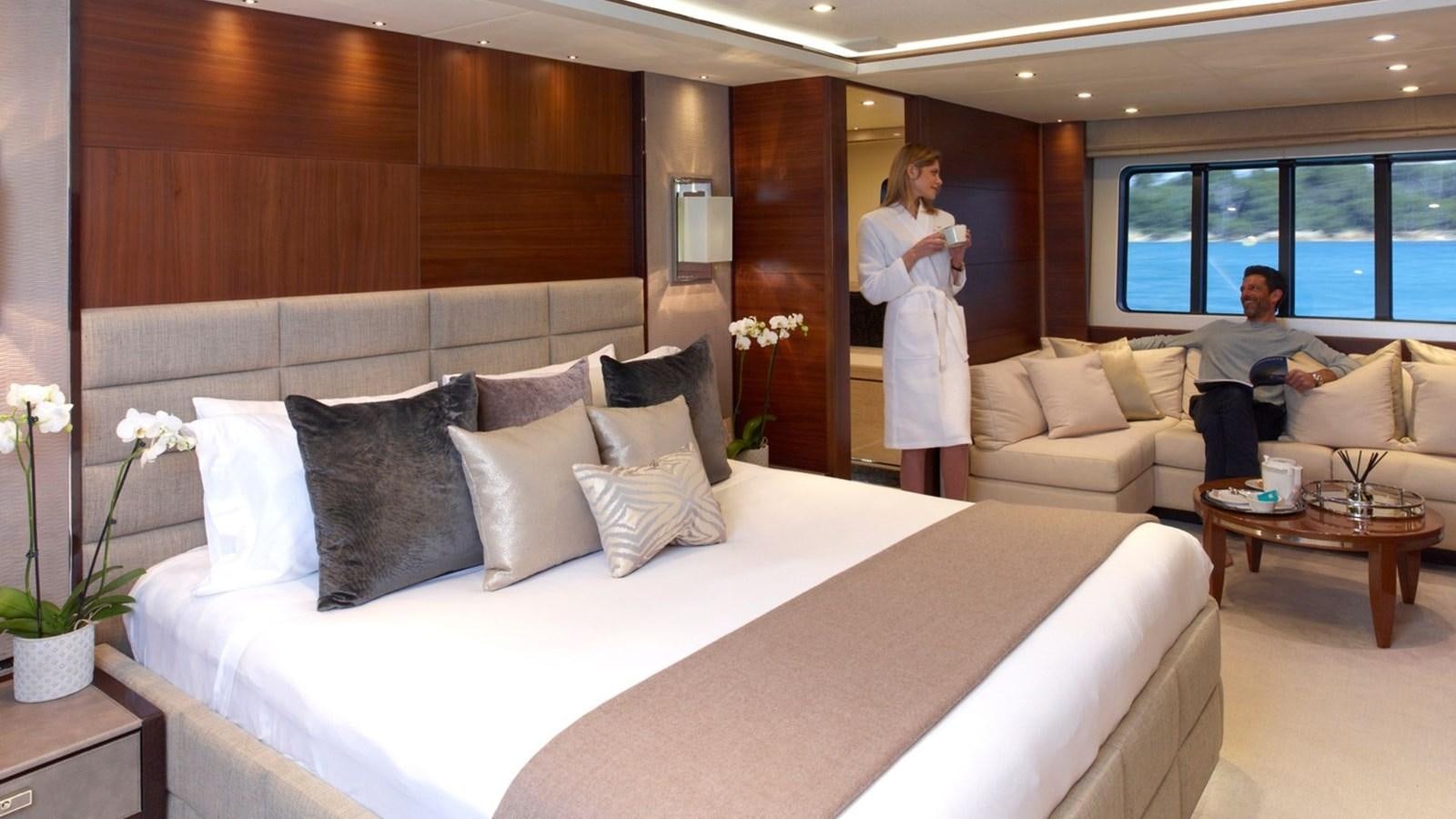 a man and a woman in a room with a large bed aboard IMPERIAL PRINCESS BEATRICE Yacht for Sale