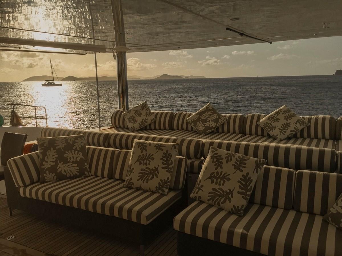 a couple of couches in a room with a body of water in the background aboard IPHARRA Yacht for Sale
