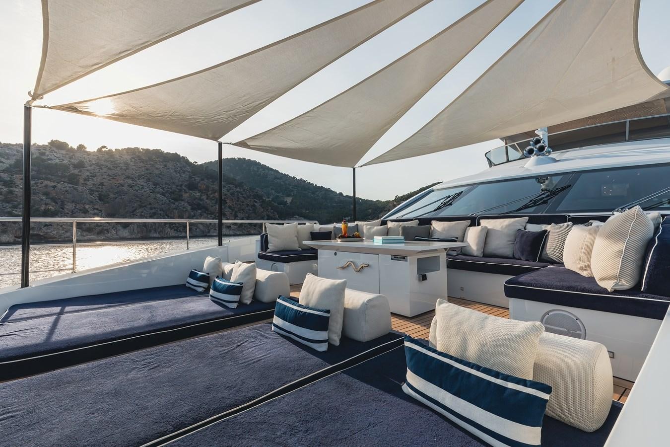a large bed with a blue and white striped pillow on it aboard NEW WAVES Yacht for Sale