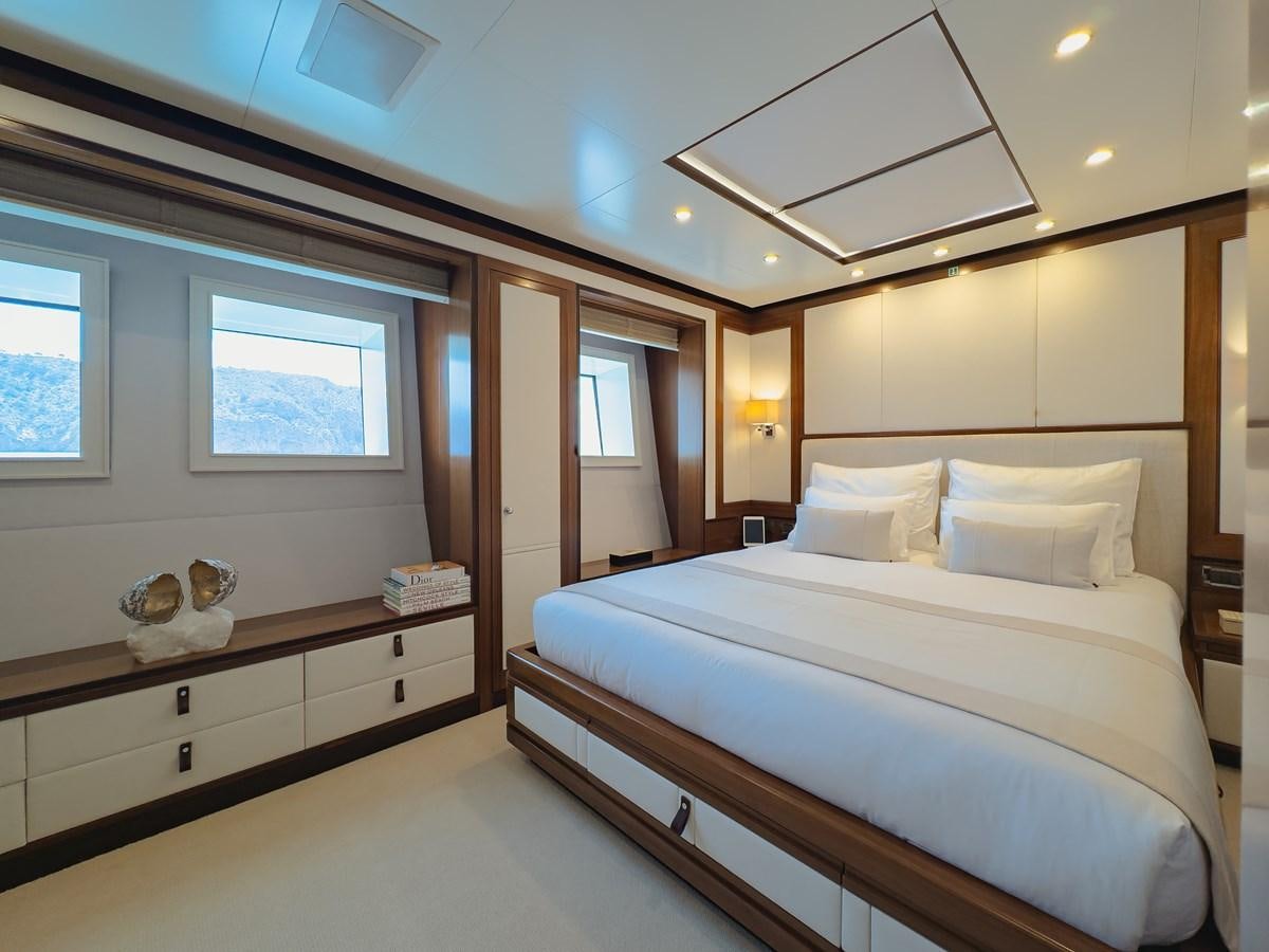 a bedroom with a bed and a desk aboard NEW WAVES Yacht for Sale