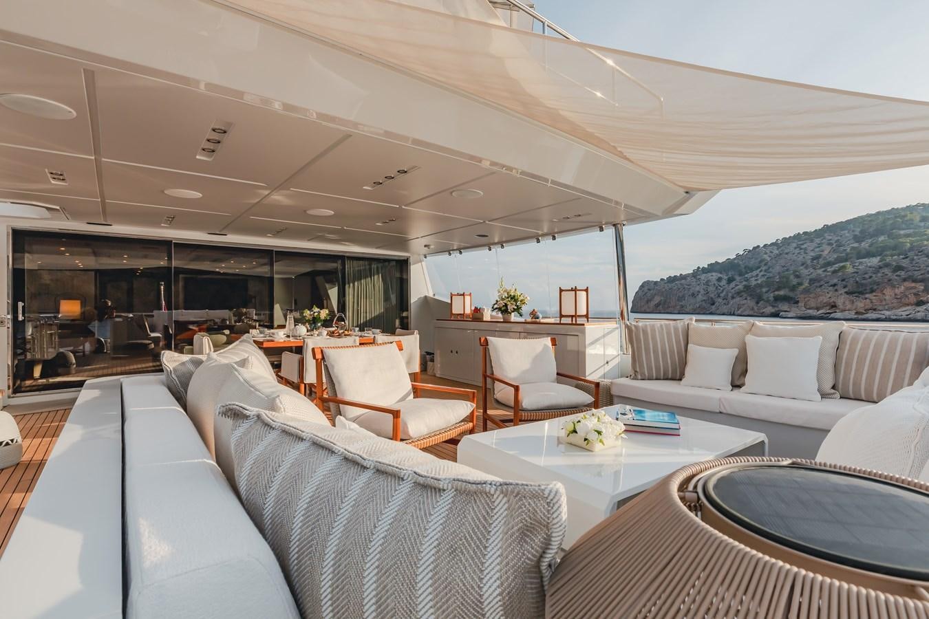 a living room with a large white sofa and a large table aboard NEW WAVES Yacht for Sale