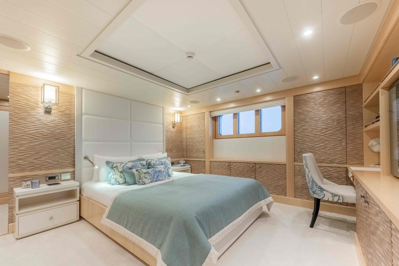 a bedroom with a bed and a chair aboard SPIRIT Yacht for Sale