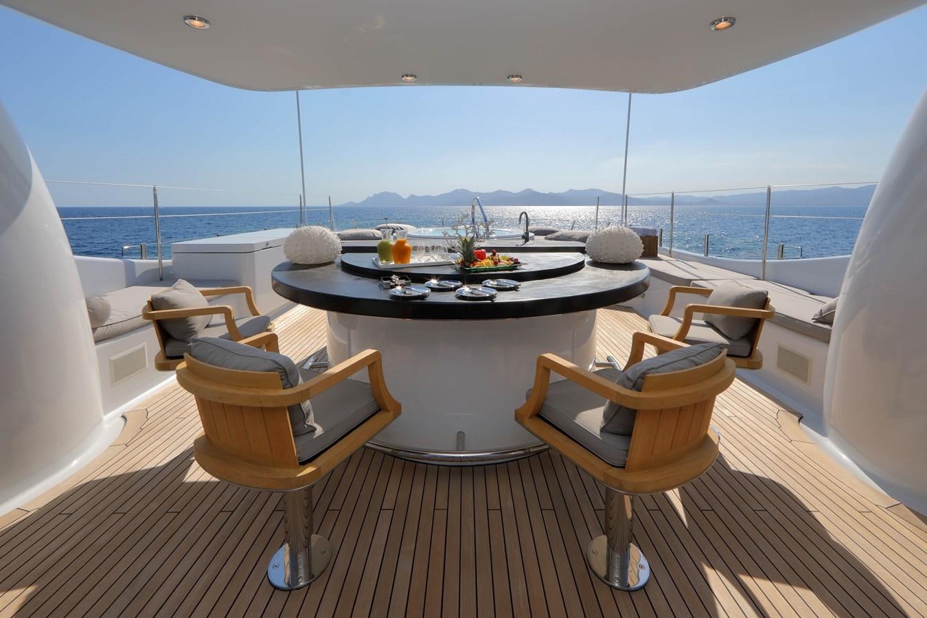 a table and chairs on a deck overlooking the ocean aboard SPIRIT Yacht for Sale