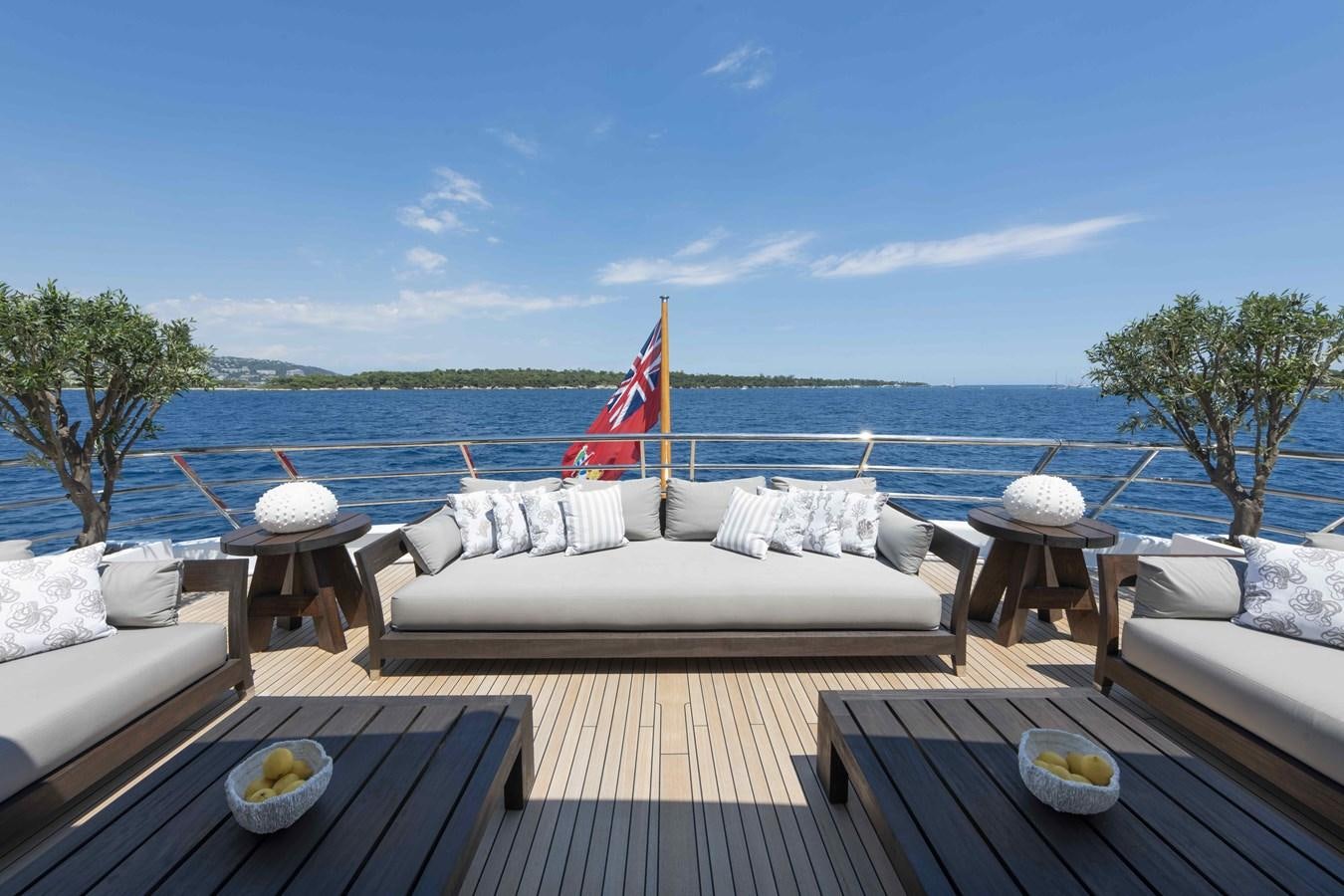 a deck with a table and chairs on it and a body of water in the background aboard SPIRIT Yacht for Sale