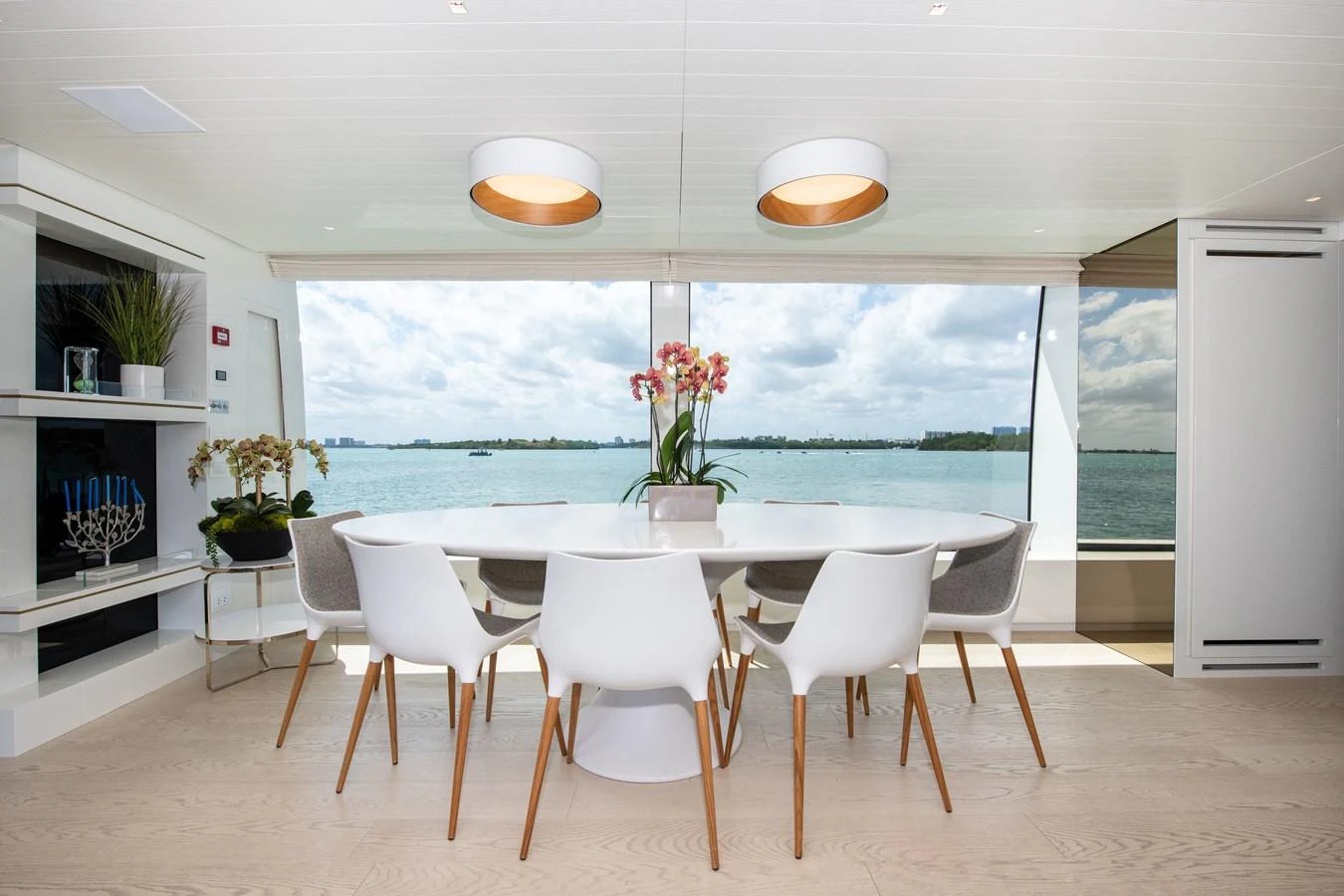 a dining table and chairs in a room with a large window aboard OUR ALEPH Yacht for Sale