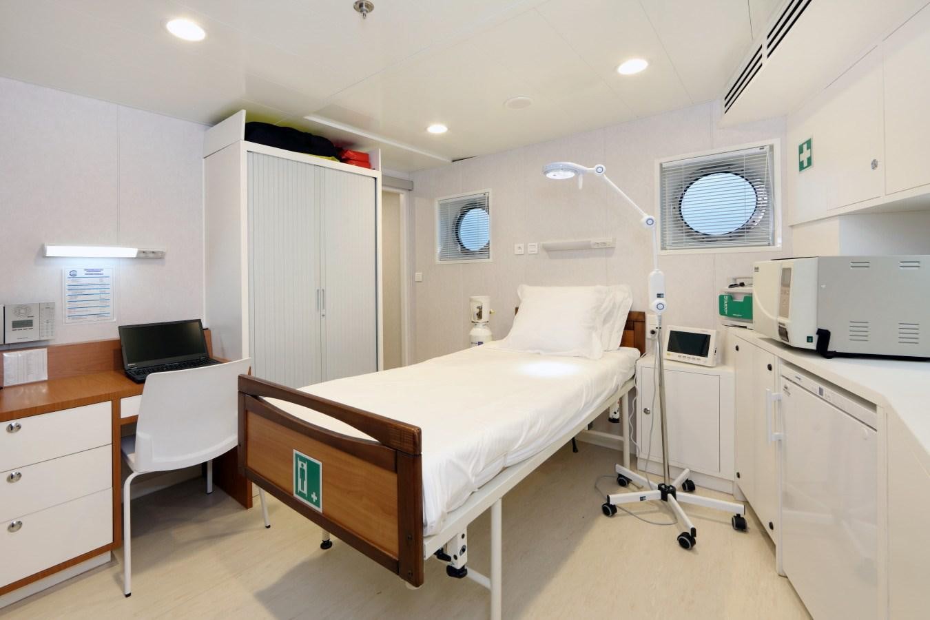 a hospital room with a bed and desk aboard YERSIN Yacht for Sale