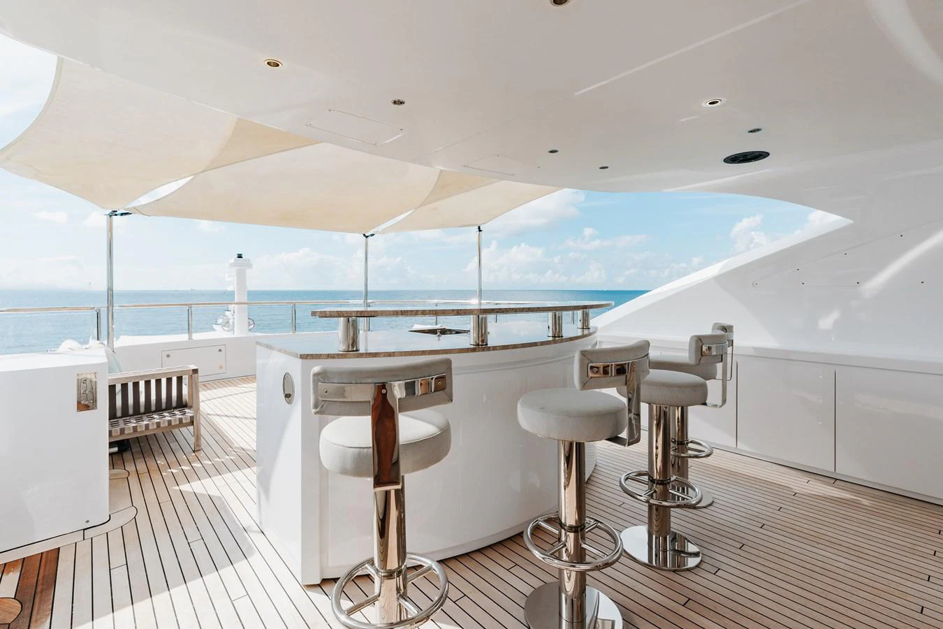 a room with a table and stools and a large window aboard ABBENTURES III Yacht for Sale
