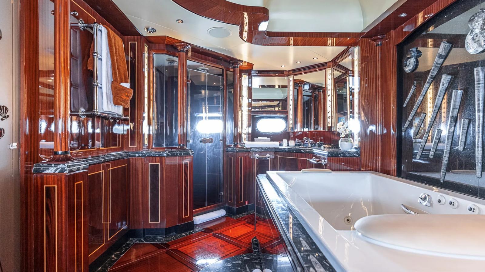 a bathroom with a bathtub and sinks aboard SVEA Yacht for Sale