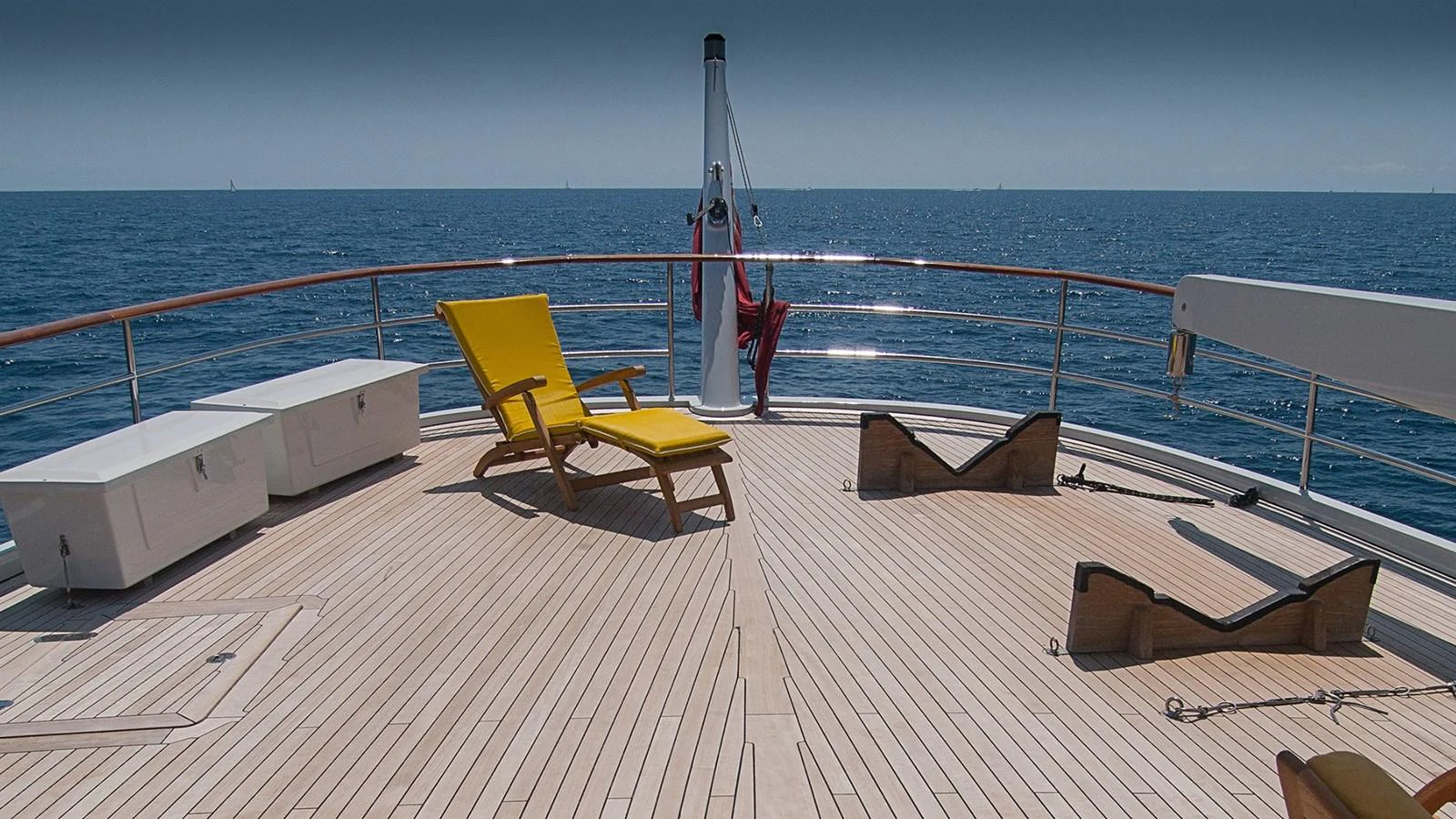 a deck with a chair and a boat on it aboard LA REINA DEL MAR Yacht for Sale