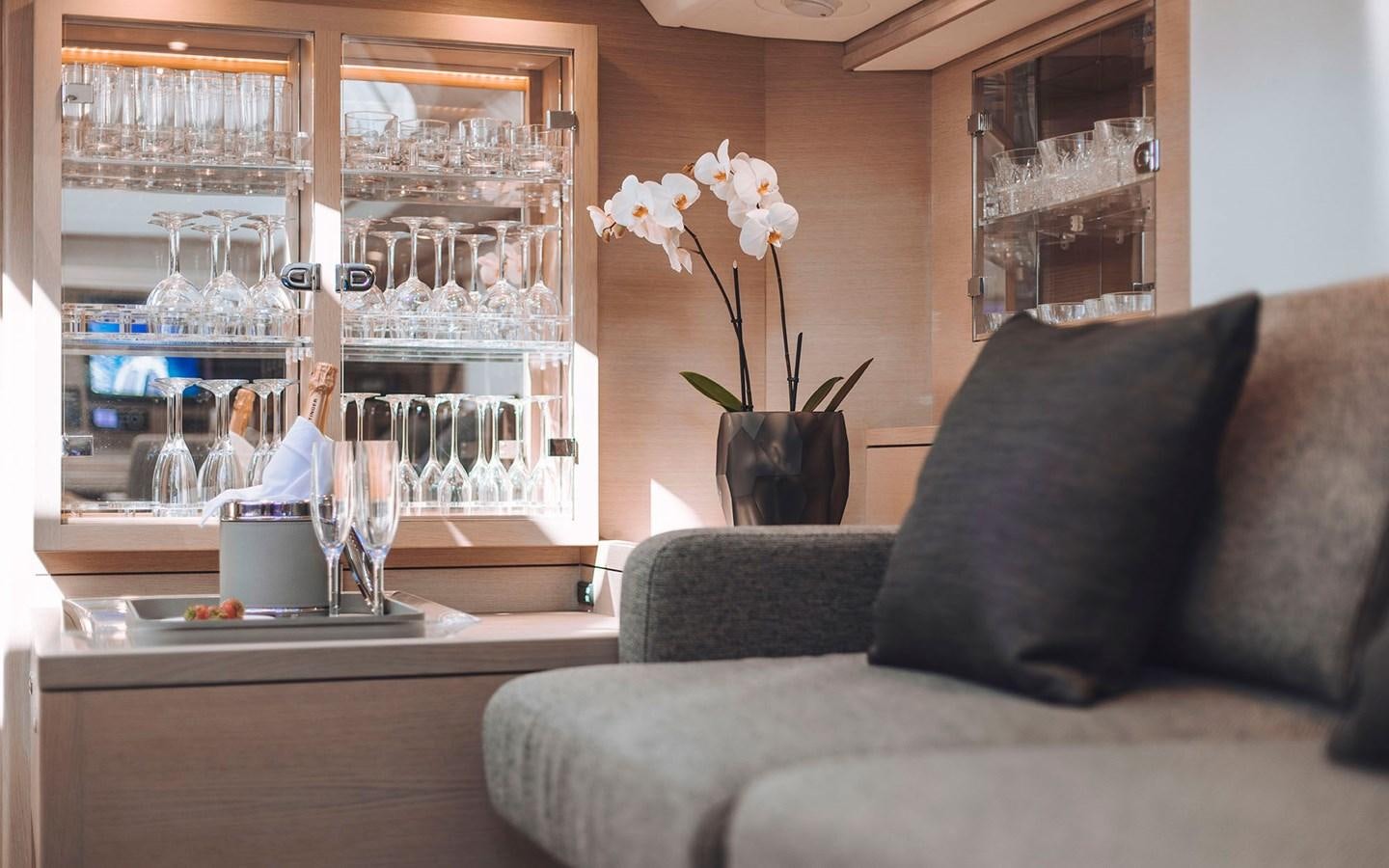 a vase of flowers sits on a coffee table aboard ENSO Yacht for Sale